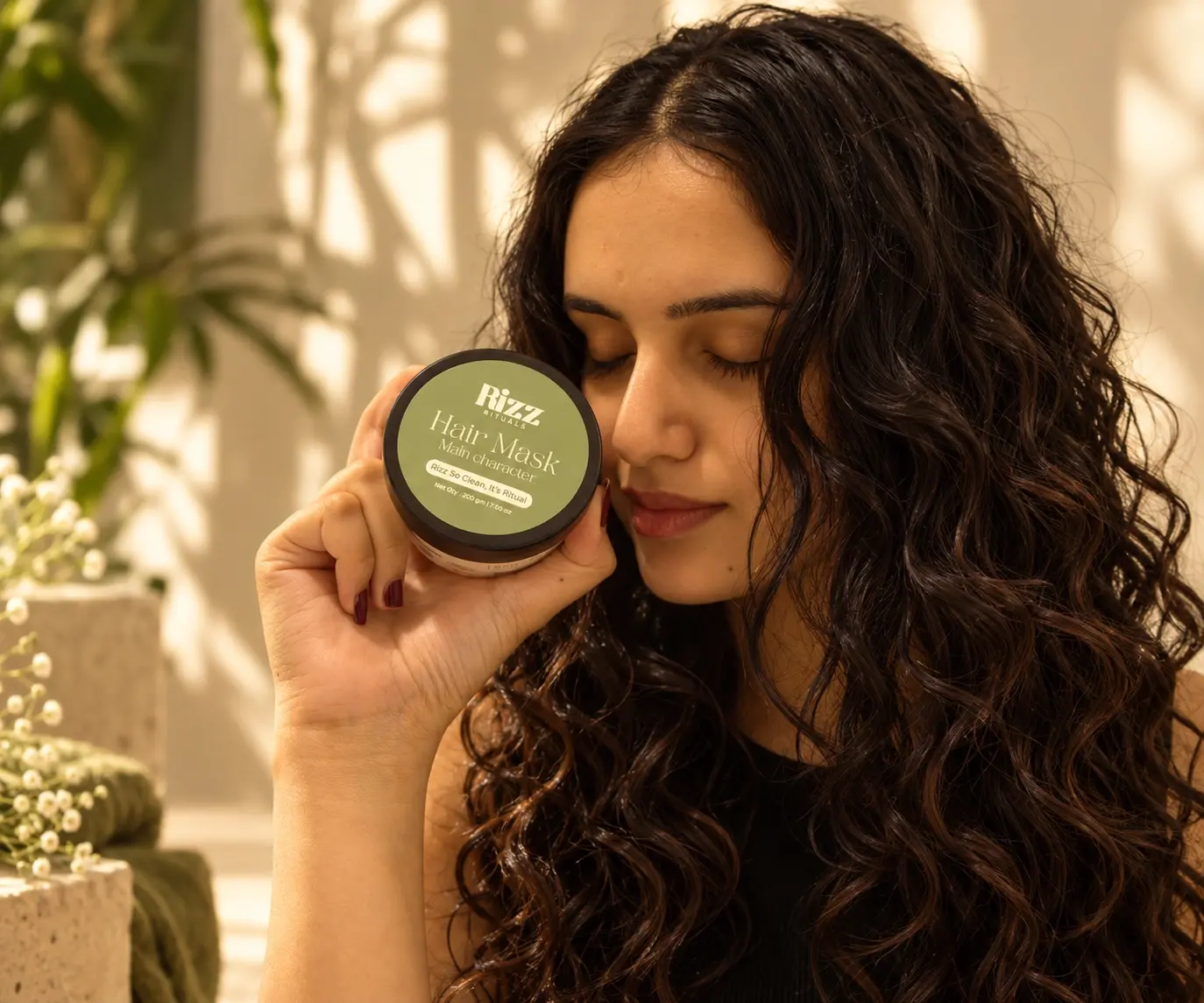 Model holding Rizz Rituals hair mask